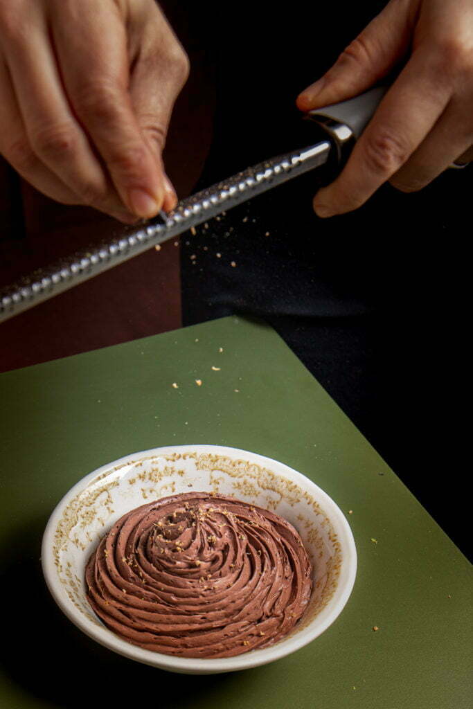 Gestes du pâtissier : chocolat râpé sur un dessert