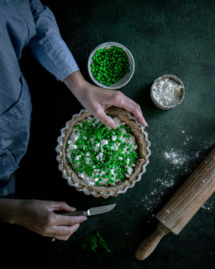 Photo culinaire d’une tarte avec une main, présence humaine