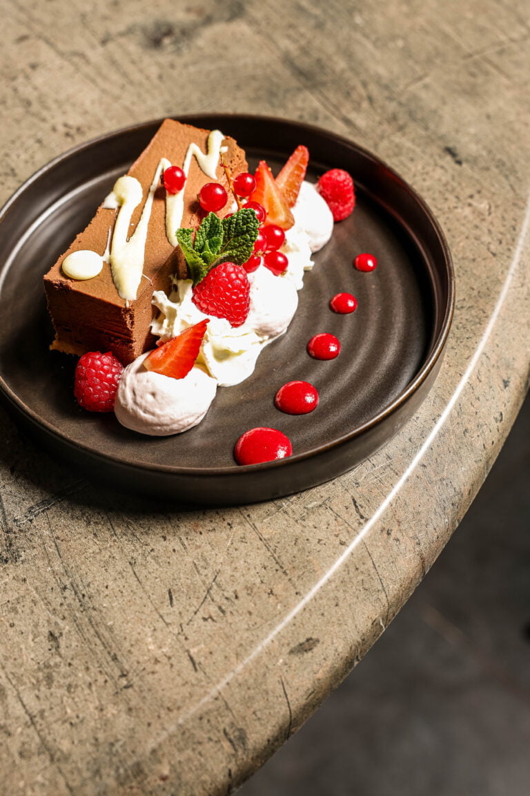 Dessert au chocolat et fruits rouges sur assiette noire