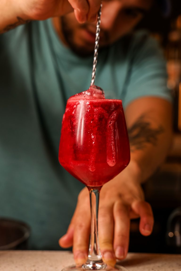 Barman préparant un cocktail rouge au bar
